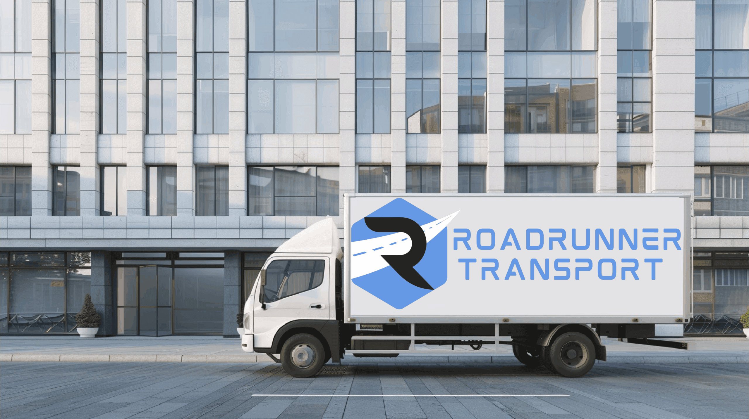 Roadrunner Transport box truck parked outside a commercial building